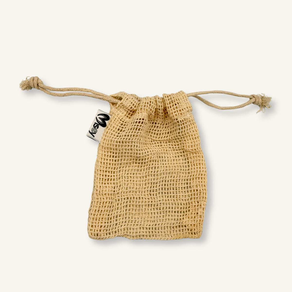 Bolsita de algodón orgánico Misey abierta, mostrando su textura natural y el cordón ajustable para transporte de jabones sólidos.