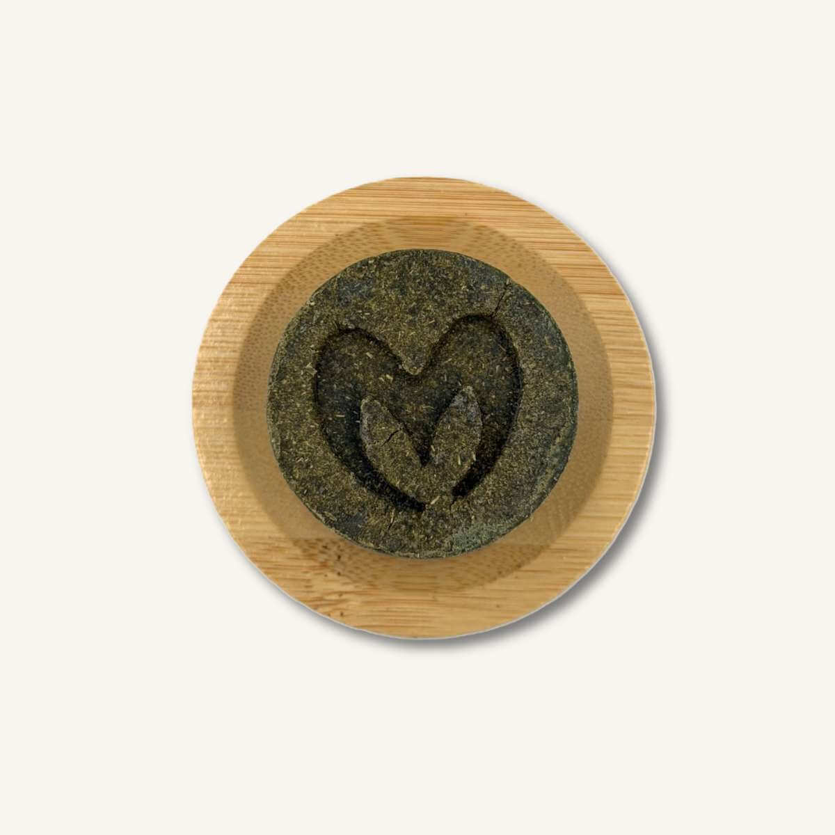 Champú sólido de Té Verde y Moringa sobre una jabonera de madera, rutina de baño zero waste y natural.