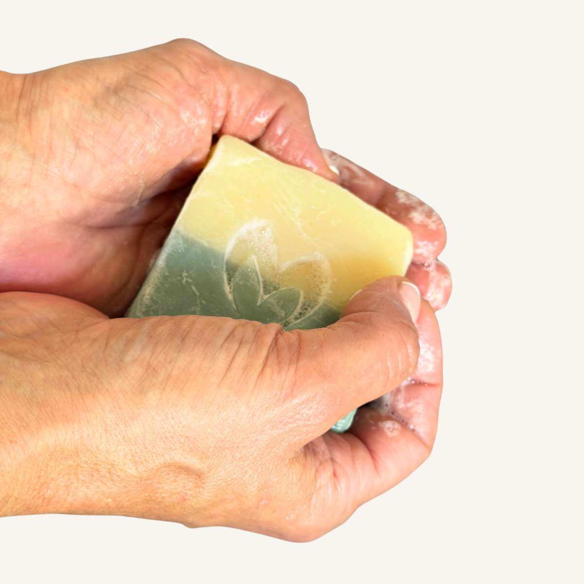 Primer plano de unas manos sosteniendo el jabón artesano del Pack Ducha Natural de Misey, mostrando su textura.